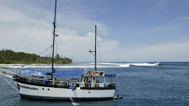 A boat heads for shore in front of one of the many surf breaks on the Mentawai Islands.