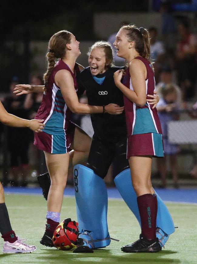 Brothers players rush in hug goal keeper Ella McLeod after she stopped a goal attempt by Saints' Talytha Macdonald to win the penalty shootout and the match for her team in the Cairns Hockey Association Under 18A Women's match between the Brothers Fury and the Cairns Saints. PICTURE: BRENDAN RADKE