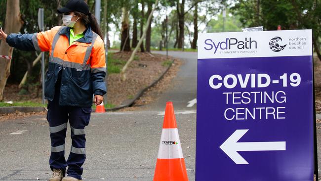 A worker directing cars at the Warringah Aquatic Centre Pop-up Drive-through COVID-19 Testing site. Picture: NCA NewsWire / Gaye Gerard