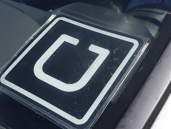 FILE - In this July 15, 2015, file photo, Uber driver Karim Amrani sits in his car parked near the San Francisco International Airport parking area. Uber said Thursday, April 7, 2016, it will pay at least $10 million to settle a case in which California prosecutors alleged it misled passengers over the quality of its driver background checks. (AP Photo/Jeff Chiu, File)