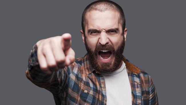 RendezView. Hey you! Furious young bearded man pointing you and shouting while standing against grey background. Angry man. Angry men.