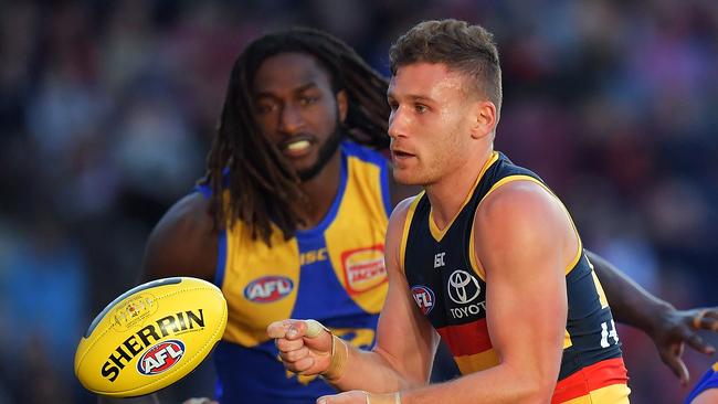 Rory Laird fires off a handball with Nic Naitanui in hot pursuit. Picture: Daniel Kalisz/Getty Images