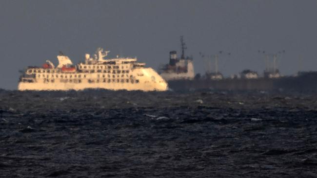 VThe Greg Mortimer, flanked by a a ship of the Uruguayan Navy off the port of Montevideo on April 6. Picture: Olivier Morin/AFP