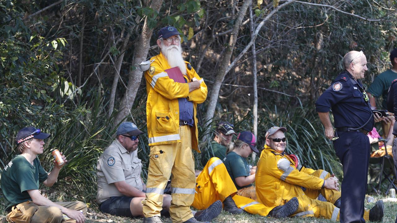 Exhausted firefighters resting by the roadside at Noosa Banks. Picture: Peter Wallis