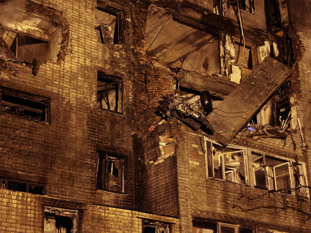 The chassis of a Sukhoi Su-34 military jet sticks out of a partially destroyed nine-storey apartment building after it crashed in a residential area. Picture: AFP