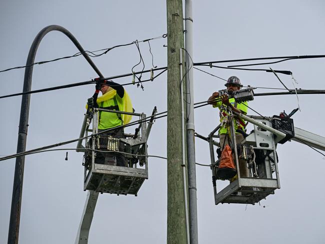 Internet service workers work secure cables in Kissimmee, Florida, on October 8, 2024, ahead of the expected landfall of Hurricane Milton. Milton regained power on October 8 to become a Category 5 storm with maximum sustained winds of 165 mph (270 kph) as it barrels towards west-central coast of Florida forecast to make landfall late October 9, according to the National Hurricane Center. (Photo by GIORGIO VIERA / AFP)