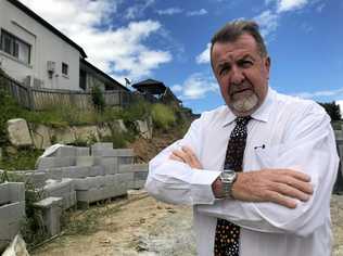 FALLING RISK: Councillor Paul Tully outside the Aristotle Street home that engineers say could slip into the excavation site below. Picture: Hayden Johnson