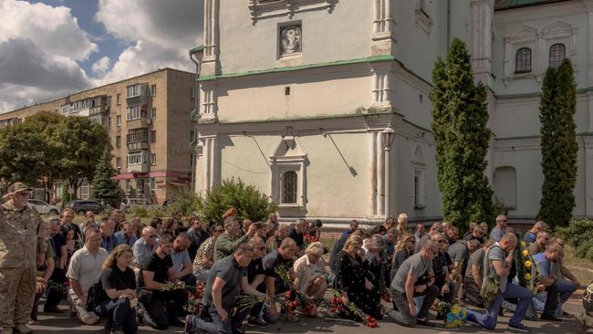 Mourners kneel to pay their respect during the funeral of six Ukrainian servicemen, who were killed since the Kursk offensive began. Picture: Roman Pilipey/AFP