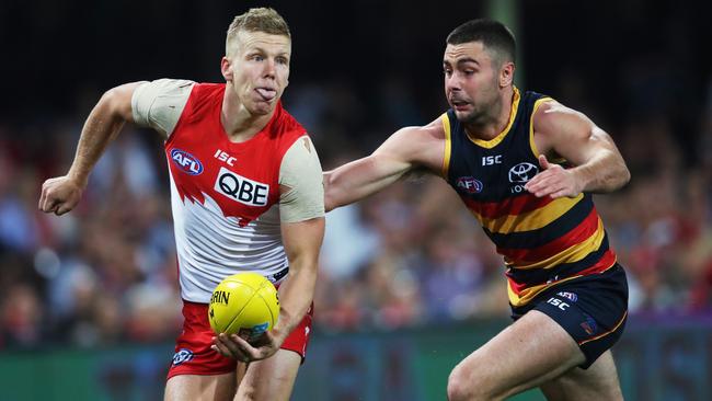 Dan Hannebery handballs ahead of Rory Atkins. Picture: Phil Hillyard