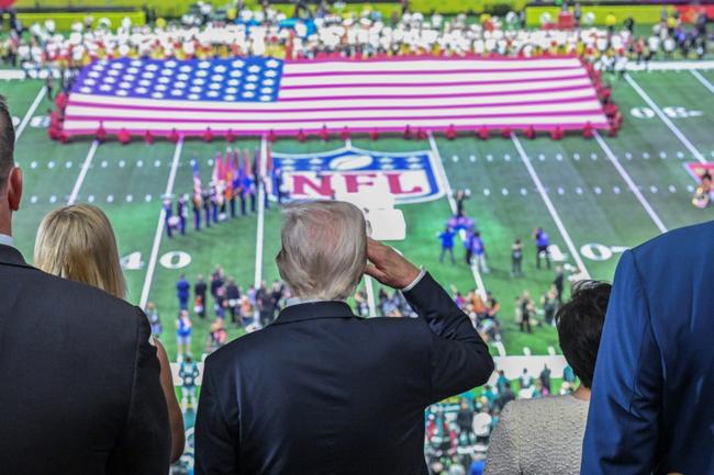 US President Donald Trump salutes as the national anthem is played before the start of the Super Bowl