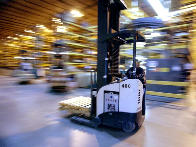 An employee drives a forklift in a warehouse at Amazon's fulfillment Center in Fernley, Nevada on Tuesday, December 13, 2005. Between Thanksgiving and Christmas the Fernley Center will process approximately 2 million orders. Ken James / Bloomberg News