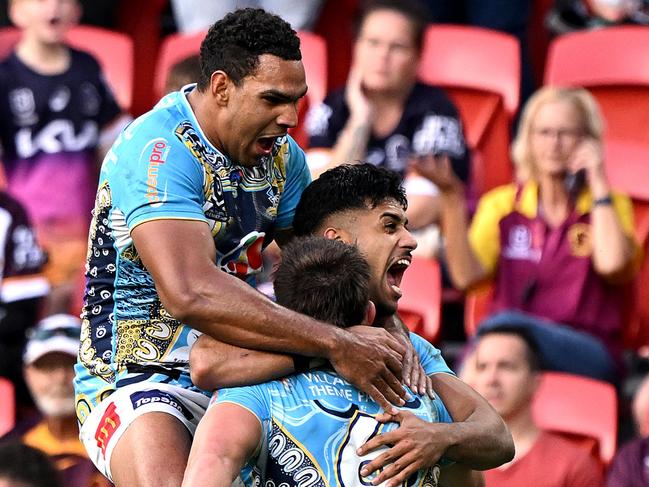 BRISBANE, AUSTRALIA - MAY 26: Chris Randall of the Titans is congratulated by team mates after scoring a try during the round 12 NRL match between Brisbane Broncos and Gold Coast Titans at Suncorp Stadium, on May 26, 2024, in Brisbane, Australia. (Photo by Bradley Kanaris/Getty Images)