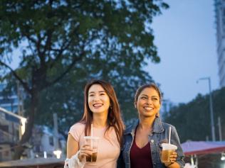 Girlfriends enjoy the local street market in Jalan Alor in Kuala Lumpur, Malaysia