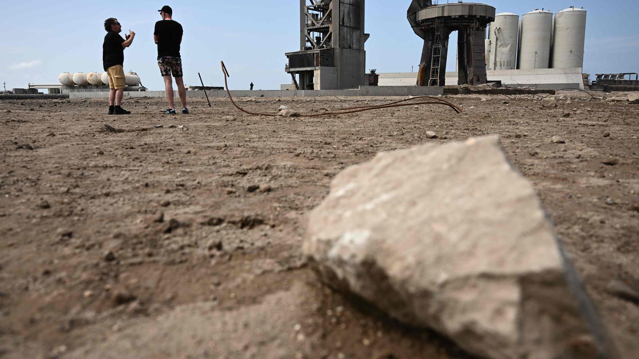 Members of the public walk through a debris field at the launch pad on April 22, 2023. The rocket successfully blasted and the Starship capsule had been scheduled to separate from the first-stage rocket booster three minutes into the flight but separation failed to occur and the rocket blew up. Picture: AFP