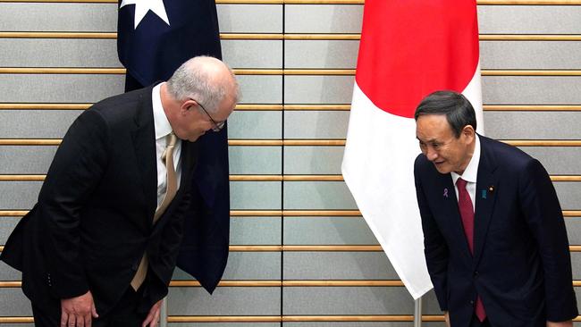 Australia's Prime Minister Scott Morrison, left, and Japan's Prime Minister Yoshihide Suga (R) bow at the start of their meeting at Suga's official residence in Tokyo. Picture: Eugene Hoshiko/AFP