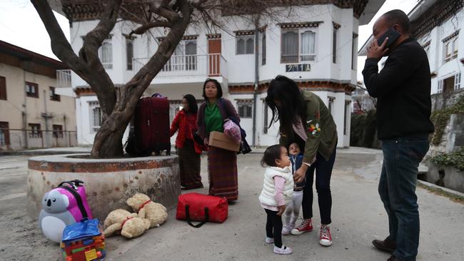 Leaving at dawn for the five-hour drive, the twins' sister Ugyen holds Nima and Dawa. Picture: Alex Coppel