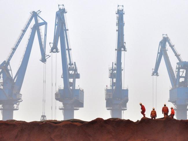 Workers prepare ore from Australia to be transported from a port in Tianjin, China. Picture: Vincent Du/Reuters