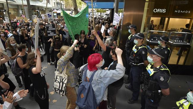 Police watch the crowds as they march through Melbourne’s CBD. Picture: Jason Edwards