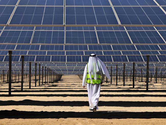 An Emirati man walks beneath photovoltaic panels at the al-Dhafra Solar Photovoltaic independent Power Producer project near Abu Dhabi. The United Arab Emirates inaugurated one of the world's biggest solar plants, two weeks before the oil-rich Gulf state hosts UN climate talks. Picture: AFP