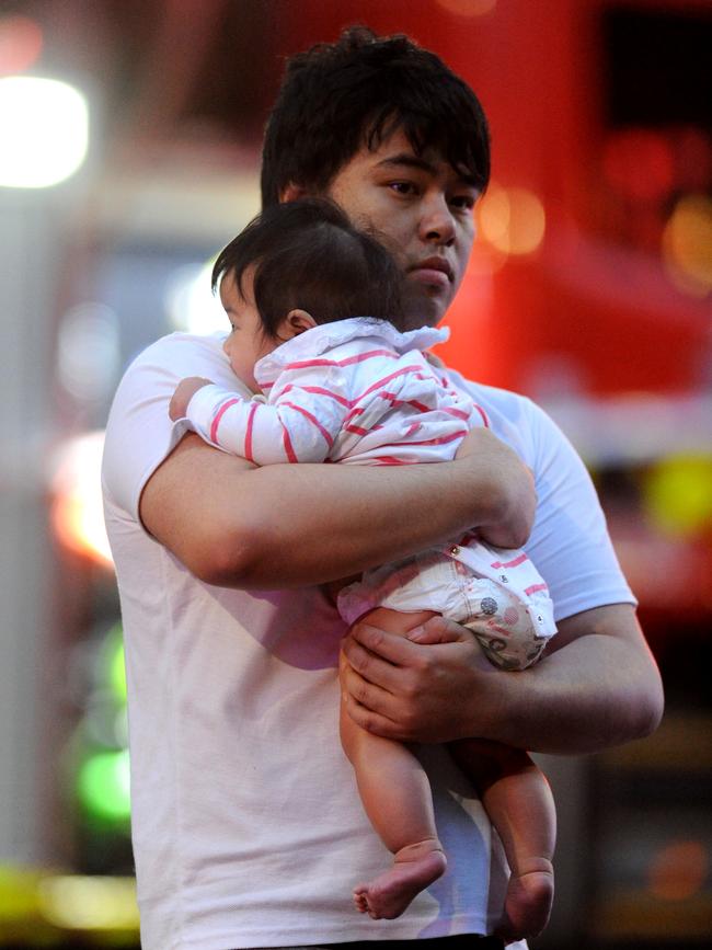 A residents flees the fire. Picture: Andrew Henshaw