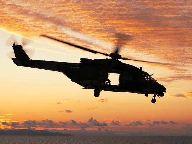 Australian Army MRH-90 Helicopter departs HMAS Adelaide after conducting deck landing certifications during Exercise Sea Wader 2020.