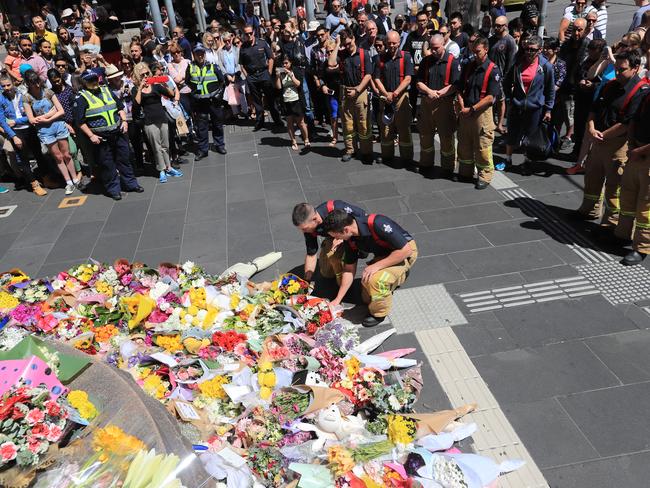 Melbourne Fire Brigade lay flowers and onlookers watch on. Picture: Alex Coppel.