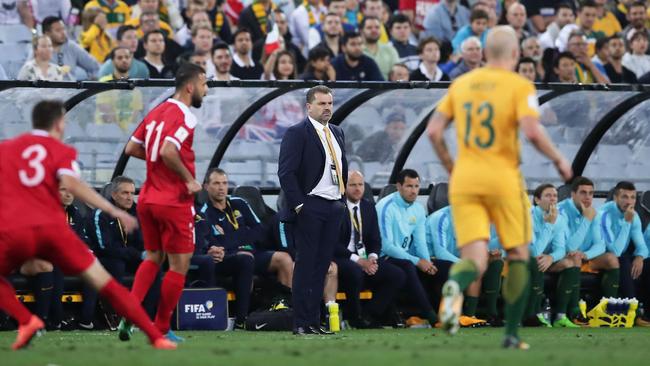 Socceroos coach Ange Postecoglou looks on from the sidelines with Aaron Mooy in the foreground during Tuesday night’s playoff against Syria.