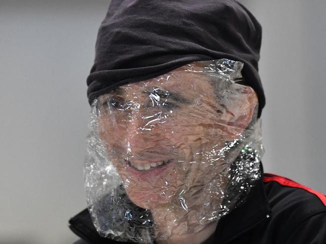 A man is seen with plastic wrapped around his face to protect himself from the Coronavirus (COVID-19) at the Brisbane domestic airport terminal in Brisbane, Monday, March 23, 2020. The Queensland Government has announced that they will close the state's borders to stop the spread of the Coronavirus (COVID-19) outbreak, beginning at midnight on Wednesday and they will force anyone entering Queensland to quarantine themselves for 14 days after their arrival. (AAP Image/Darren England) NO ARCHIVING