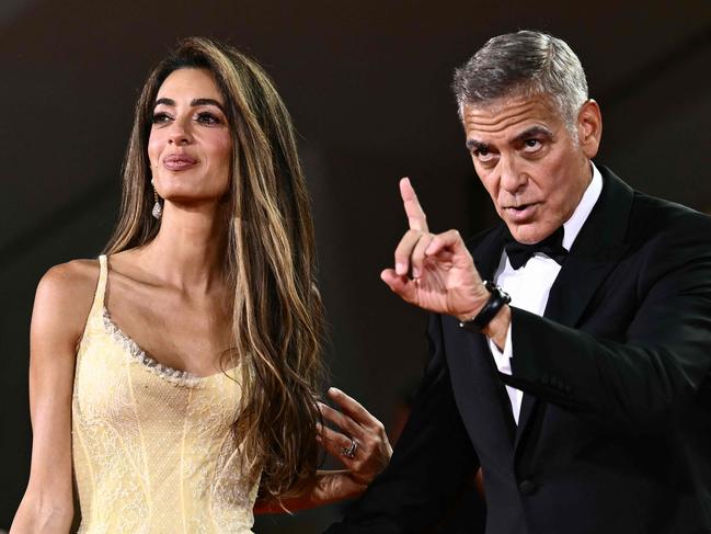 TOPSHOT - Amal Clooney and George Clooney attend the red carpet of the movie "Wolfs" presented out of competition during the 81st International Venice Film Festival at Venice Lido, on September 1, 2024. (Photo by Marco BERTORELLO / AFP)