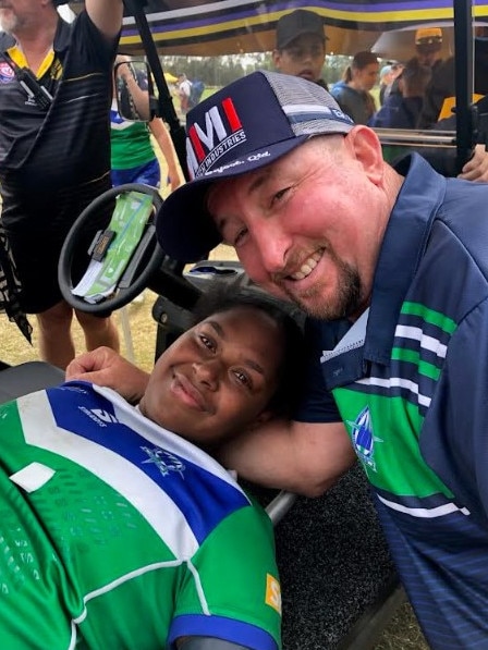 The Cathedral College coach Scott Peters with injured player Harmonie Fauid, who broke her leg in the team's Confraternity Shield grand final win.