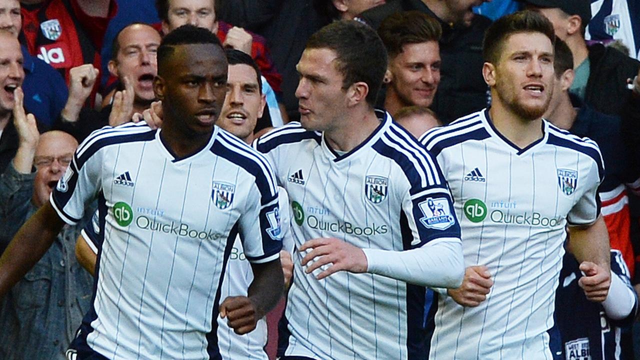 West Bromwich Albion's Burundian striker Saido Berahino (L) celebrates scoring their first goal with West Bromwich Albion's English midfielder Craig Gardner (2nd L) and West Bromwich Albion's Belgian defender Sebastien Pocognoli (R) during the English Premier League football match between Liverpool and West Bromwich Albion at Anfield in Liverpool, north west England on October 4, 2014. AFP PHOTO / PAUL ELLIS RESTRICTED TO EDITORIAL USE. No use with unauthorized audio, video, data, fixture lists, club/league logos or “live” services. Online in-match use limited to 45 images, no video emulation. No use in betting, games or single club/league/player publications.