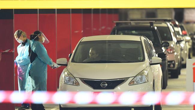 People queue in cars for testing at Northland shopping centre in Melbourne. Picture: James Ross/AAP