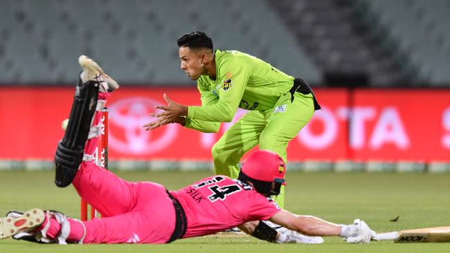 Jordan Silk of the Sixers makes the crease as Tanveer Sangha takes the ball during the Big Bash League match between the two Sydney sides.