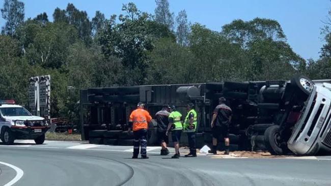 A truck rolls over on the slip road to the M1 at Yatala.