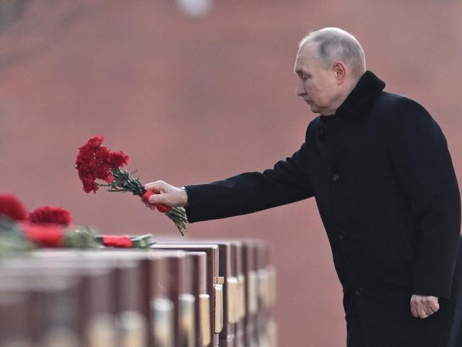 Russian President Vladimir Putin lays flowers at the Moscow Kremlin Wall in the Alexander Garden during an event marking Defender of the Fatherland Day in Moscow on February 23, 2023. (Photo by Pavel Bednyakov / Sputnik / AFP)