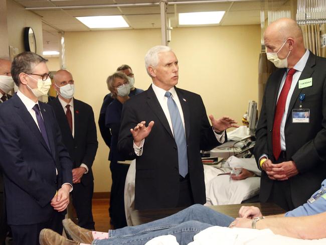 Vice President Mike Pence, center, and Dr. Michael Joiner visit with Dennis Nelson, right, who survived the coronavirus, during Pence's visit to the Mayo Clinic Tuesday, April 28, 2020, in Rochester, Minn., where he toured the facilities supporting COVID-19 research and treatment. (AP Photo/Jim Mone)