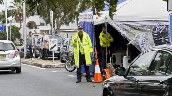 Queensland Police waving through a line of traffic at the Griffith St border check point in Coolangatta. Photo: Jessica Lamb