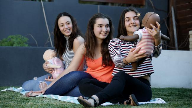 Pricilla Tarabay (left) Chloe Hassall and Jenna Poncini, all 15 years old, with the robotic baby used in the Virtual Infant Parenting program. Picture: Mark Calleja