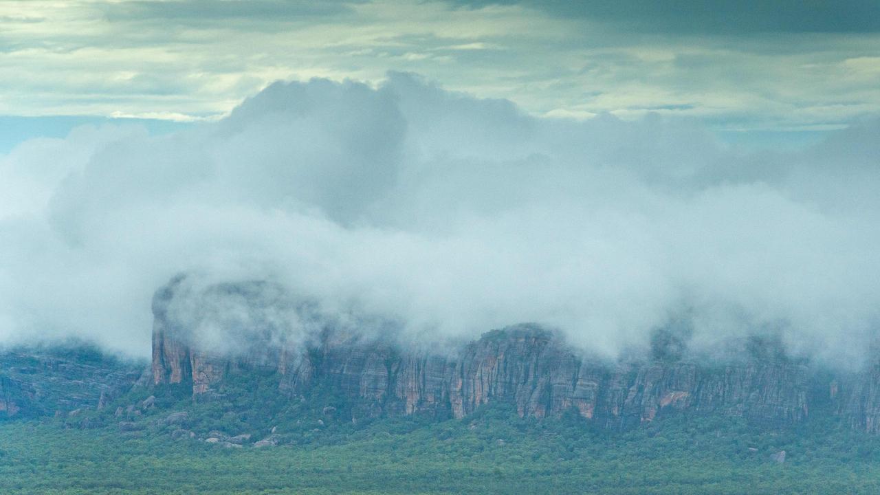 Kakadu National Park comes alive during the wet season. Kakadu Air are celebrating their 40th anniversary of flying in the Territory and relish the opportunity to show the NT News a new perspective of the park after rainfall. The escarpment is shrouded in cloud in the morning light. Picture: Che Chorley