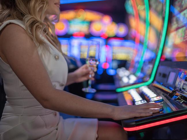 beautiful girl drinking wine alone at casino poker machine pokies istock generic