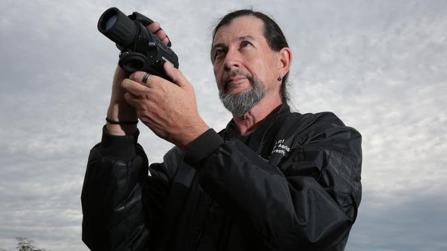 Eugene Herrera sets up his camera, hoping to capture something interesting. Picture: Robert Pozo