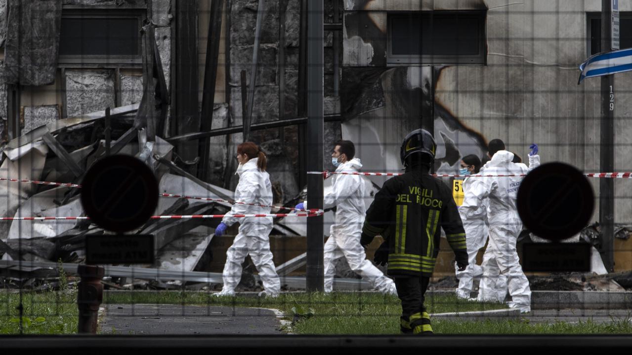 Forensic officers examine the impact point of the plane crash in Milan. Picture: Getty Images