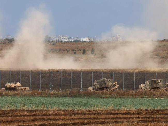 TOPSHOT - Israeli military vehicles roll near the border with the Gaza Strip on May 12, 2024, amid the ongoing conflict between Israel and the Palestinian Hamas movement. (Photo by Menahem KAHANA / AFP)