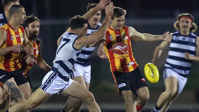 Cory Gregson gets a kick away for the Roos as Walkerville’s Daniel Woolford attempts to smother. The former Geelong man was a class above on Friday night. Picture: Dean Martin