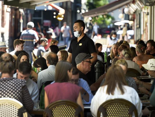 A waiter walks through lunchtime diners at a cafe on Hardware Lane in central Melbourne. Picture: Andrew Henshaw