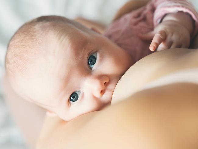 Baby eating mother's milk. Mother breastfeeding baby. Beautiful mom breast feeding her newborn child. Young woman nursing and feeding baby. Concept of lactation infant.