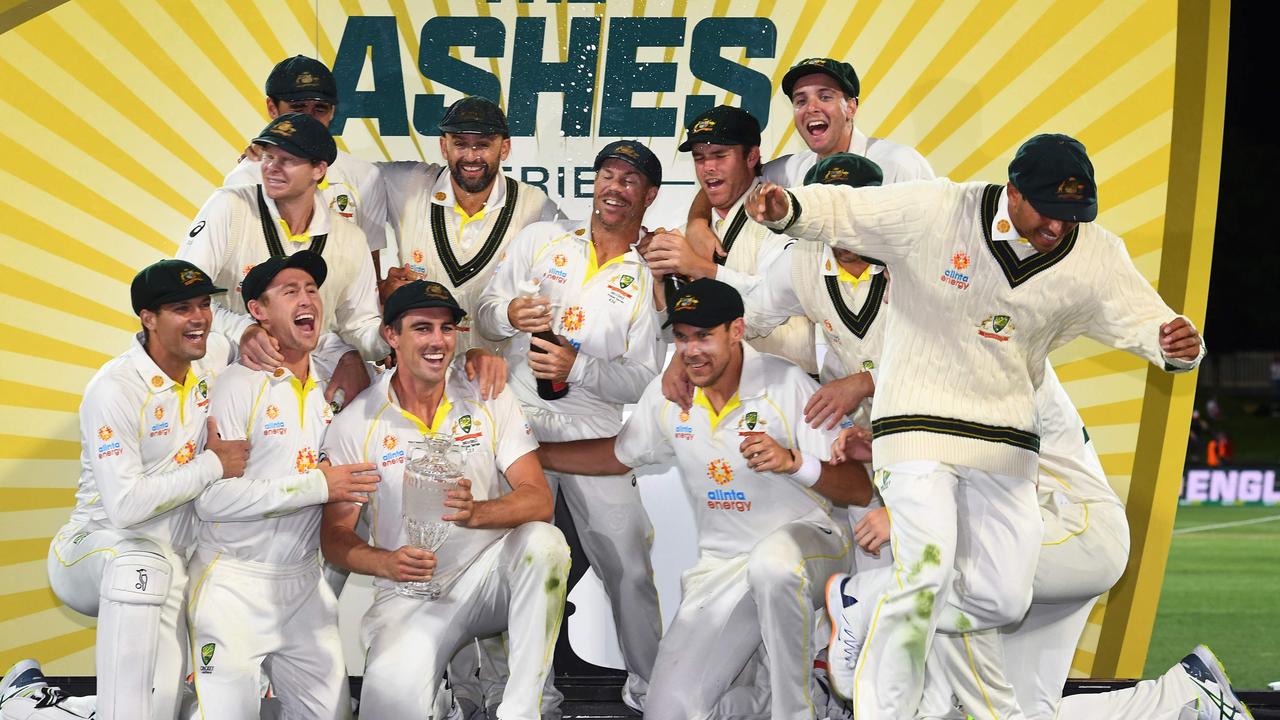 Usman Khawaja jumps off stage as the champagne bottles are popped after the fifth Test victory. Picture: William WEST/AFP
