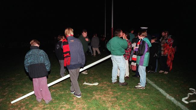 Fans make off with a point post during the infamous “lights out” match between Essendon and St Kilda in 1996.