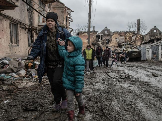 Ukrainians walk through a destroyed neighborhood in Eastern Mariupol that has recently come under control of Russia. Picture: Maximilian Clarke