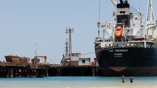 Trucks load scrap metal into a vessel for recycling while demolishing the aluminium plant at Gove. Picture: David Hancock.